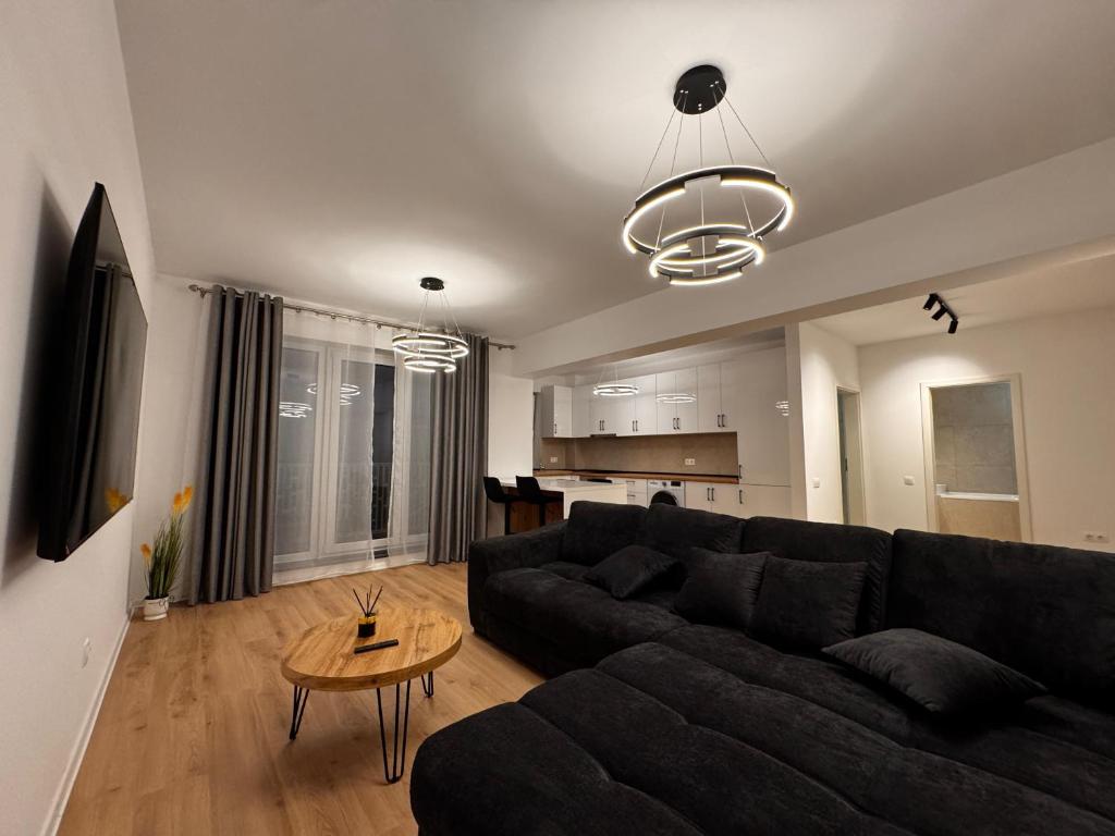un soggiorno con un divano nero e un tavolo di MOOS Aparthotel Qualis a Braşov
