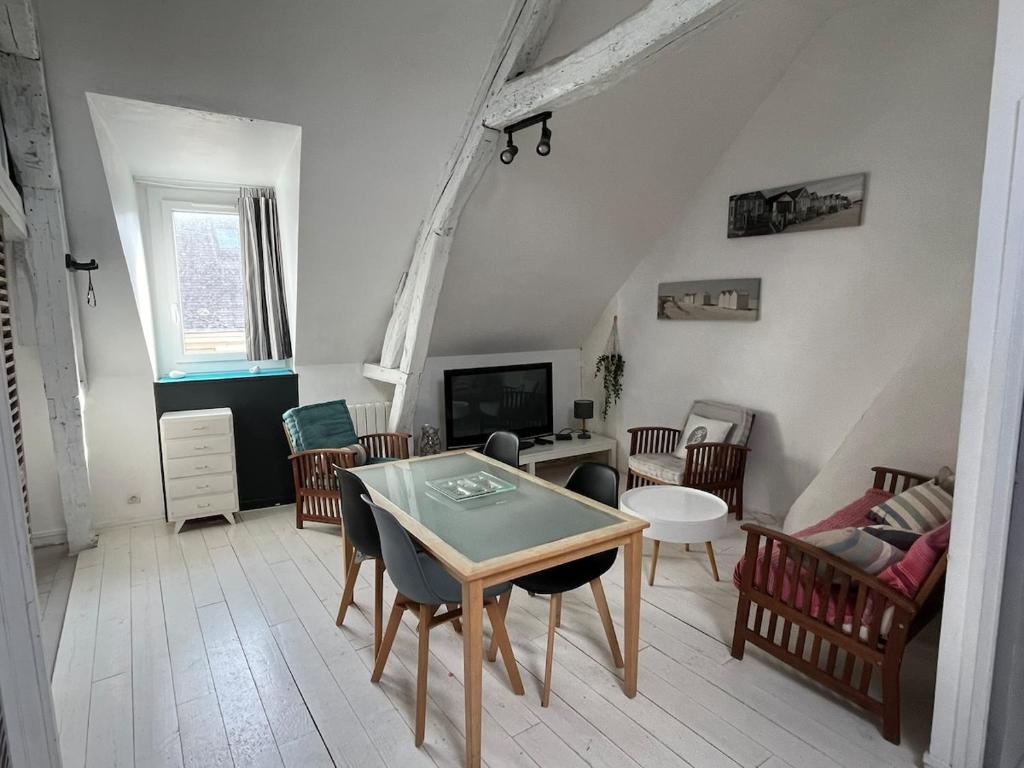 un salon avec une table et des chaises dans l'établissement Cabine du Capitaine 5, à Fécamp