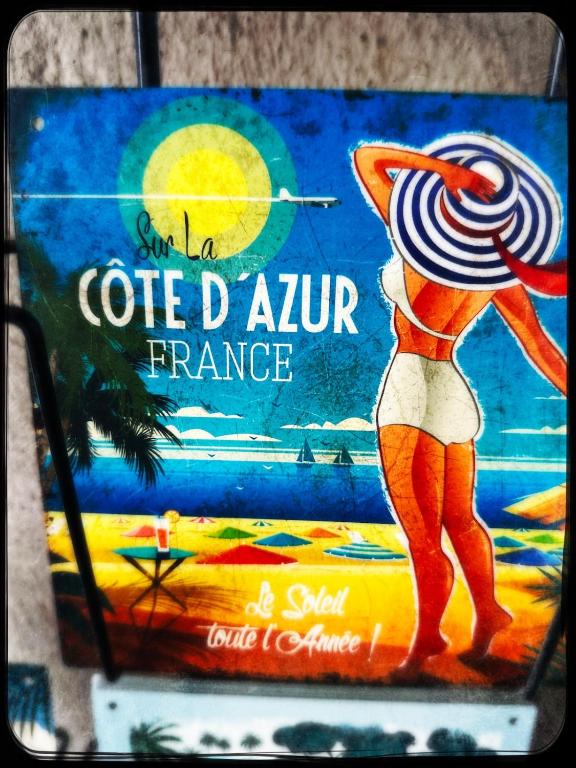 un panneau avec une femme sur la plage dans l'établissement Maison des Sables - A côté de la Plage dans le Golfe de Saint-Tropez, à Grimaud