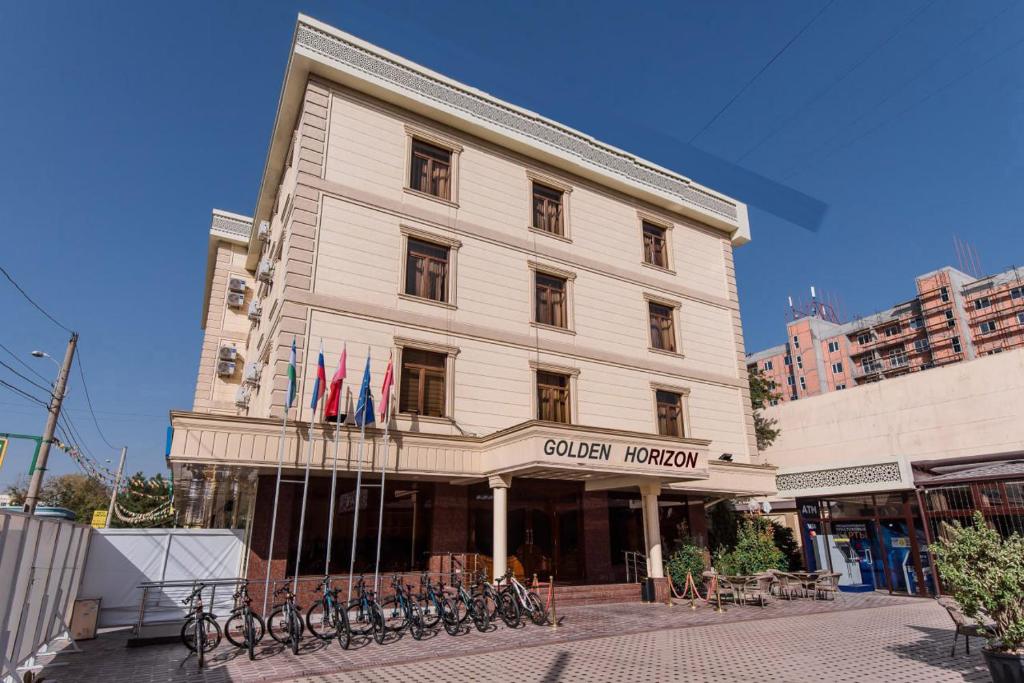 a white building with bikes parked in front of it at Golden Horizon Hotel in Tashkent