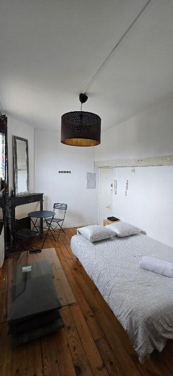 - une chambre blanche avec un lit et un piano dans l'établissement Studio Arcole Metro Botanical Garden, à Toulouse