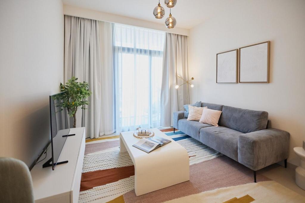 a living room with a couch and a table at Stylish 1BR Warm & Curated Interiors in Dubai