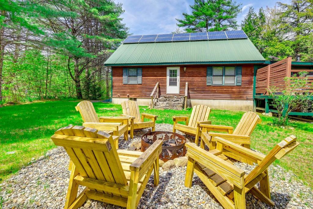 a group of wooden chairs in front of a cabin at Peaceful Family Cabin on Schroon River! in Warrensburg