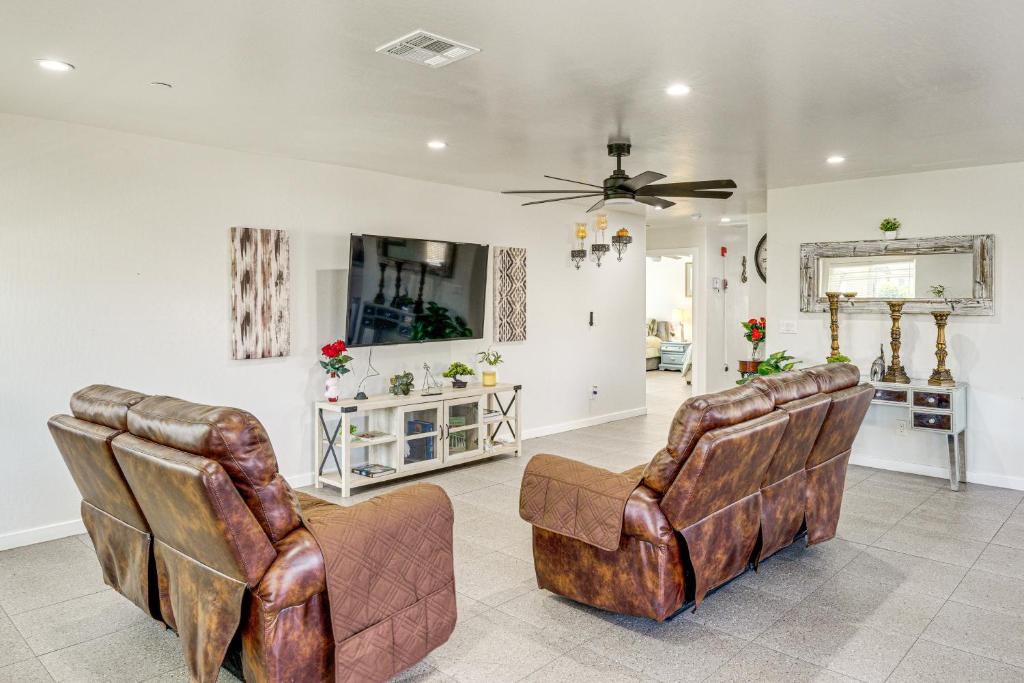 a living room with two leather chairs and a ceiling fan at 1 Mi to Rabobank Arena Home with Gazebo! in Bakersfield
