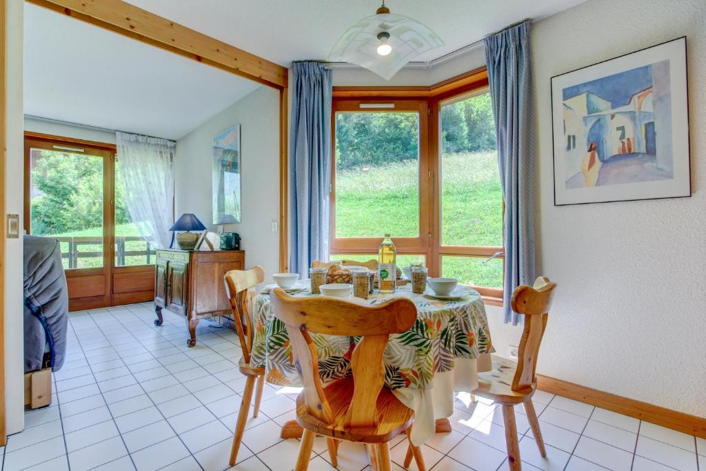 d'une salle à manger avec une table et quelques fenêtres. dans l'établissement PICARON A13, à Morzine