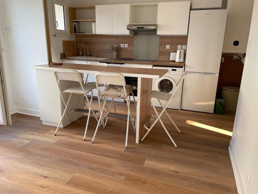 une cuisine avec une table et des chaises dans une pièce dans l'établissement Arcachon centre, à Arcachon