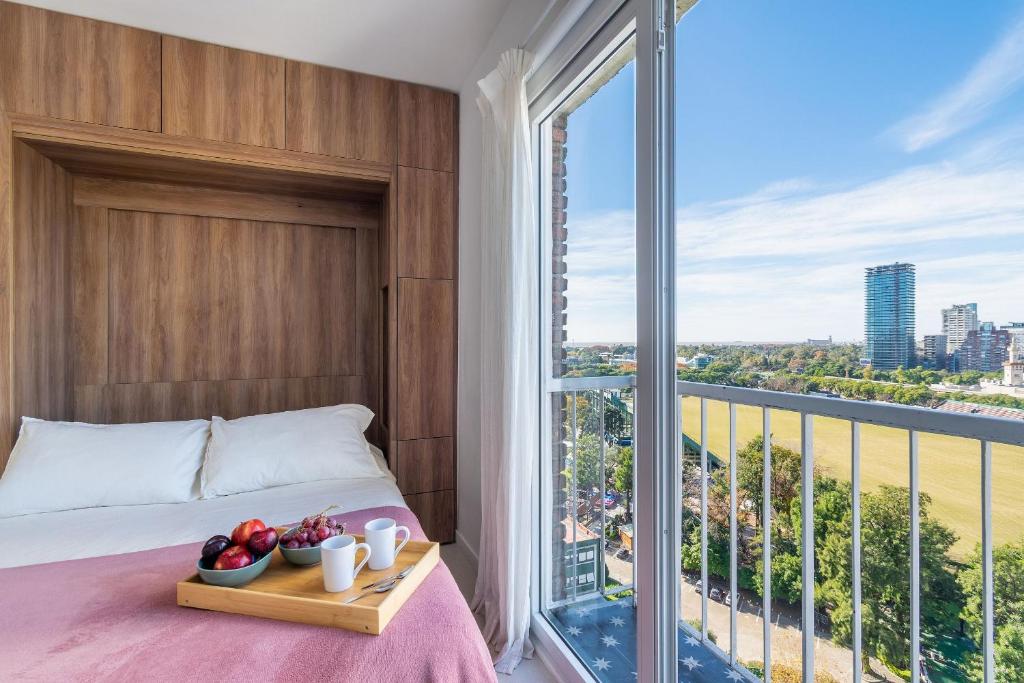 a bedroom with a bed and a large window at Estudio moderno con vista al Polo | Las Cañitas in Buenos Aires