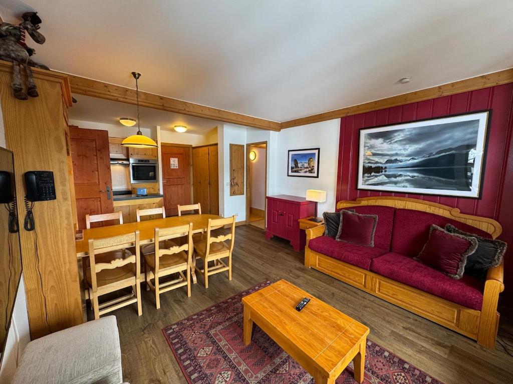 un salon avec un canapé rouge et une table dans l'établissement 2 Bedroom Apartment Arc 1950 - Sources de Marie, à Arc 1950