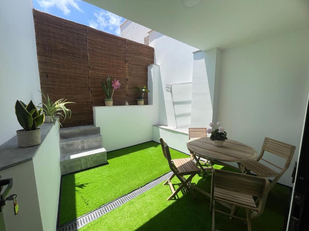 a room with a table and chairs and green grass at Casa San Juan in Santa Maria de Guia de Gran Canaria