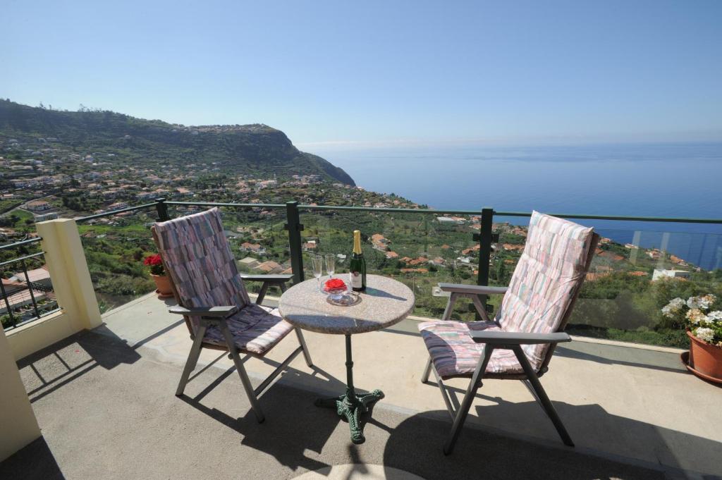 einen Tisch und zwei Stühle auf einem Balkon mit Aussicht in der Unterkunft Casa Daniela in Calheta