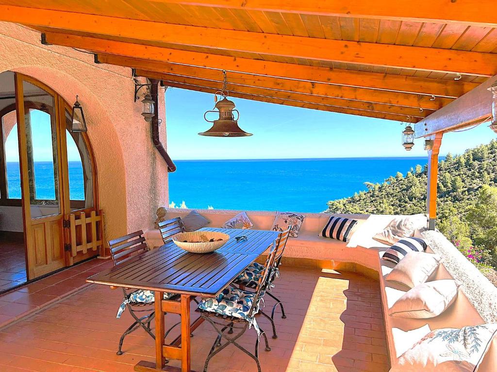 a patio with a table and a couch and the ocean at NSM Villa Carlotta E Villa Guarda che Mare in Vieste - Gargano- Puglia in Pugnochiuso
