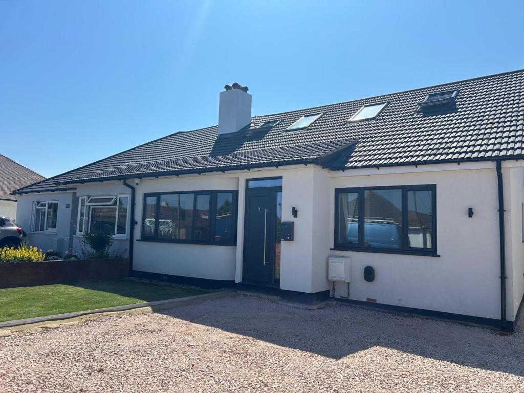 a white house with a lot of windows at The Crescent Villa Lancing in Lancing