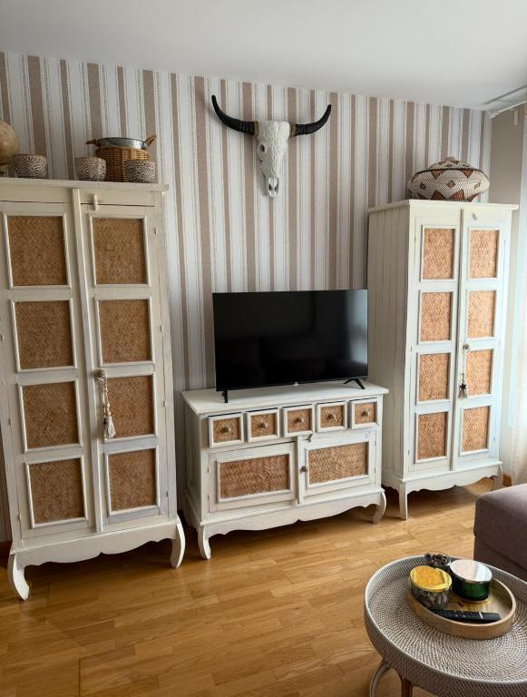 a living room with a tv on top of a cabinet at Apartamento centro de Foz con piscina in Foz