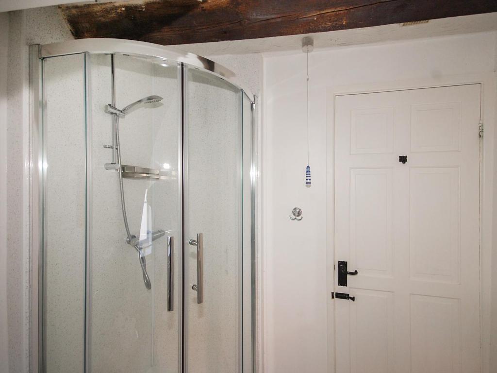 a shower with a glass door in a bathroom at Wherry Cottage in Wells next the Sea