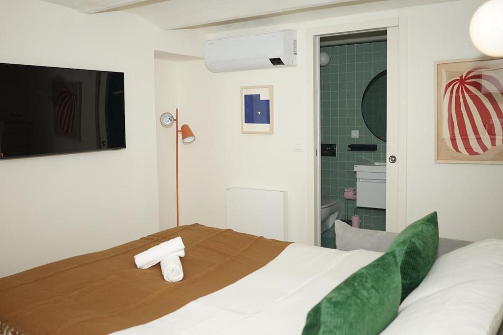 une chambre avec un lit et une télévision au mur dans l'établissement Studio La Croisette Cannes La Croix d'Or, à Cannes