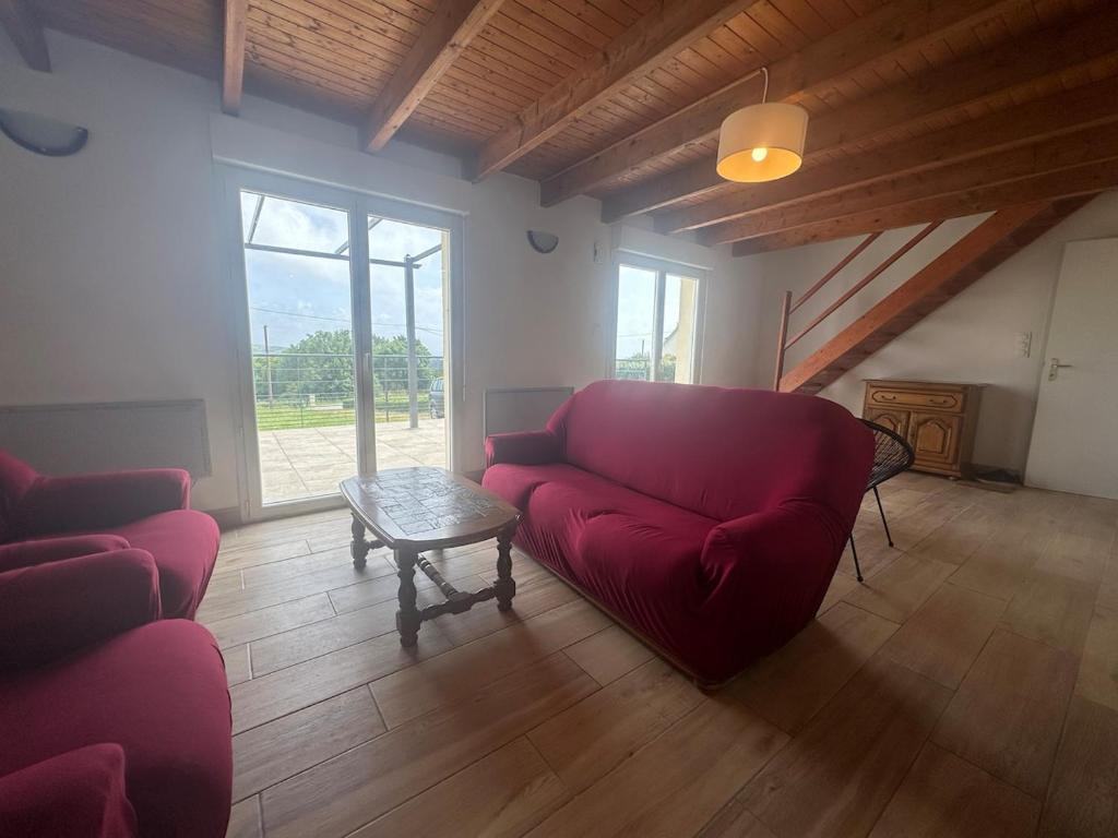 un salon avec un canapé rouge et une table dans l'établissement Maison de vacances Crozon 2ch - jardin clos, à Crozon
