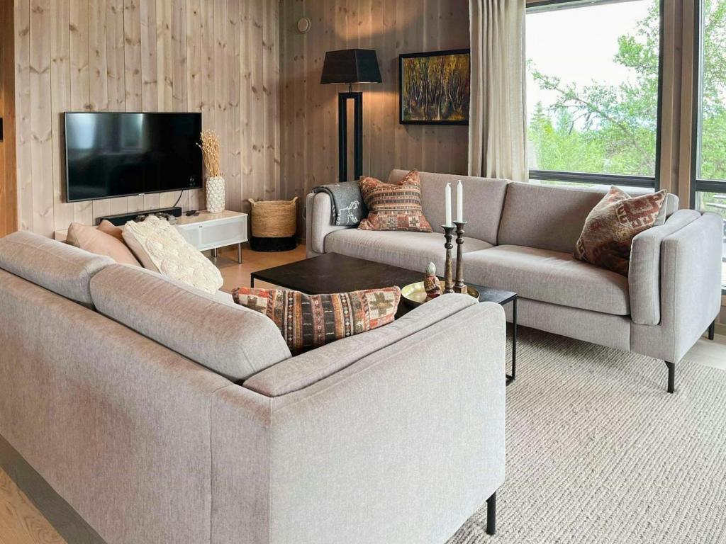 a living room with two couches and a flat screen tv at Family Cabin With Jotunheim Mountain Views in Venabygd