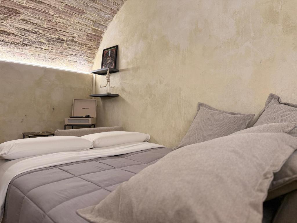 a bedroom with two beds with pillows and a wall at Casa Jazz Design & Relax nel Cuore di Perugia in Perugia
