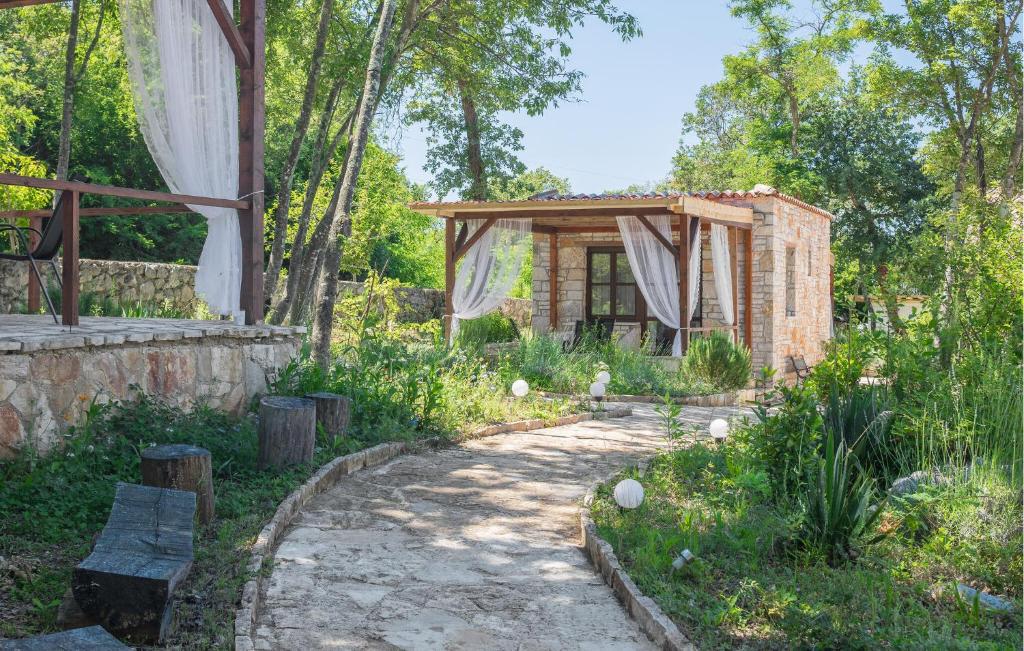 a garden with a stone path and a wooden building at Gorgeous Home In Rovinj With Wifi in Rovinj