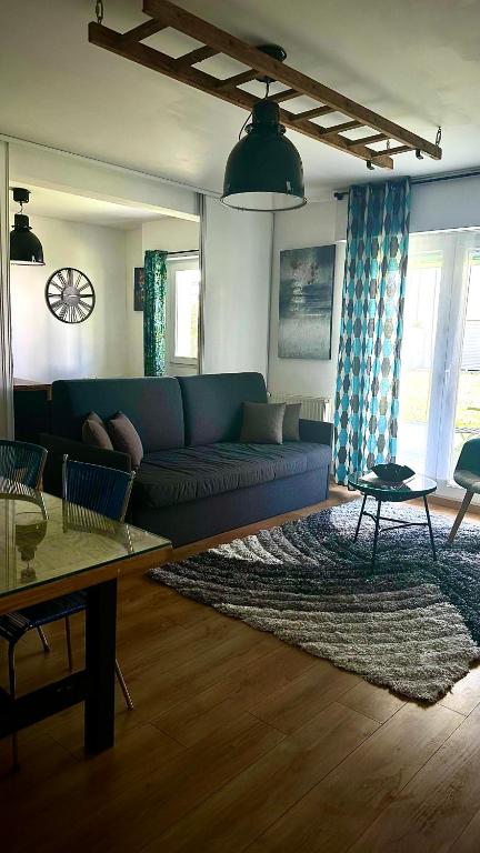 un salon avec un canapé bleu et un tapis dans l'établissement Nantes appartement plain pied proche Beaujoire, à Nantes