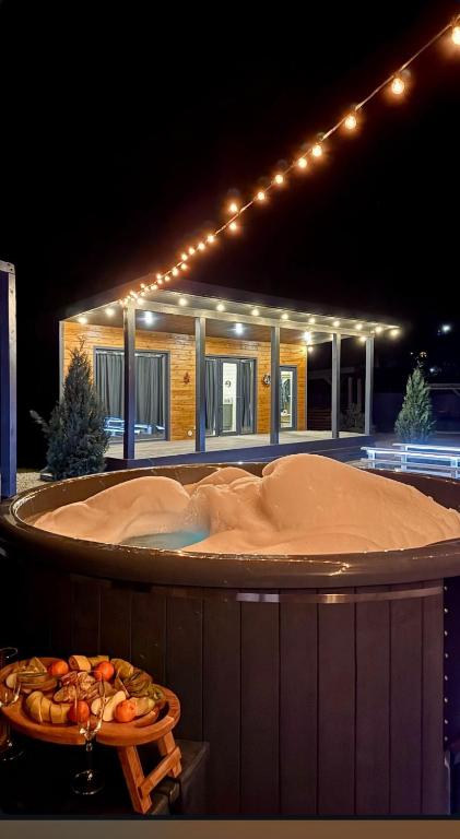 bañera de hidromasaje frente a un edificio con luces en stream housee, en Slavske
