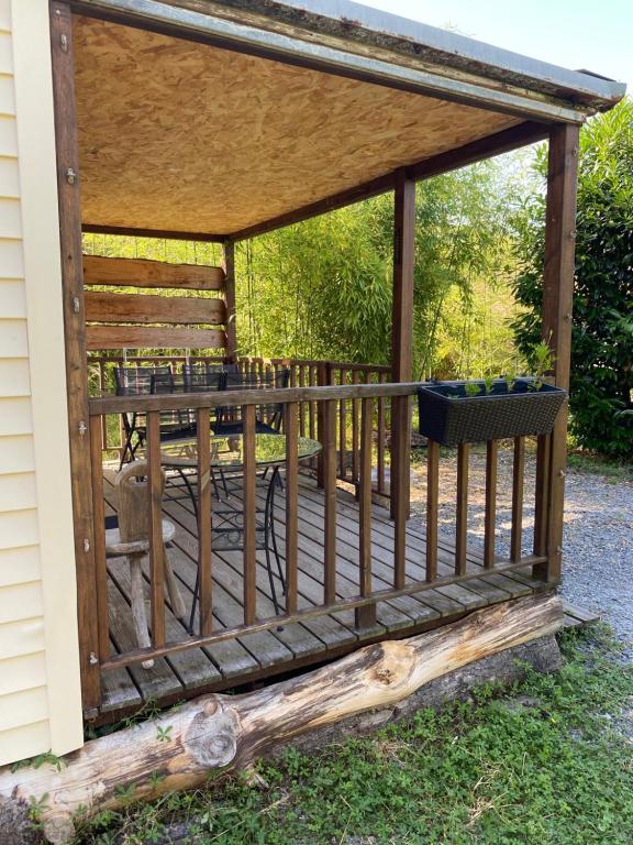 un gazebo en bois avec une clôture sur une cour dans l'établissement Cabanon Grenouille - Le Pal, à Saint-Martin-des-Lais