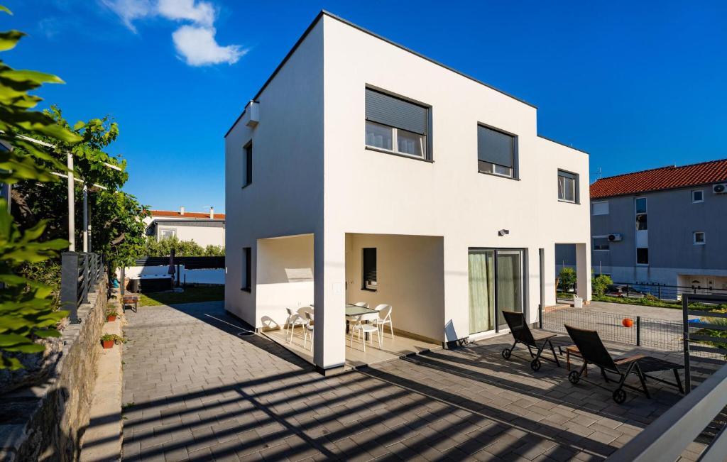 a white house with chairs and a table at 3 Bedroom Beautiful Home In Maslenica in Maslenica