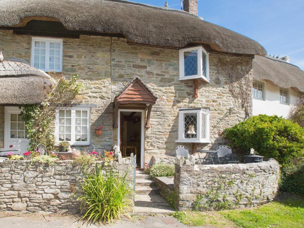 ein altes Steinhaus mit einem Strohdach in der Unterkunft Cobbles in Salcombe