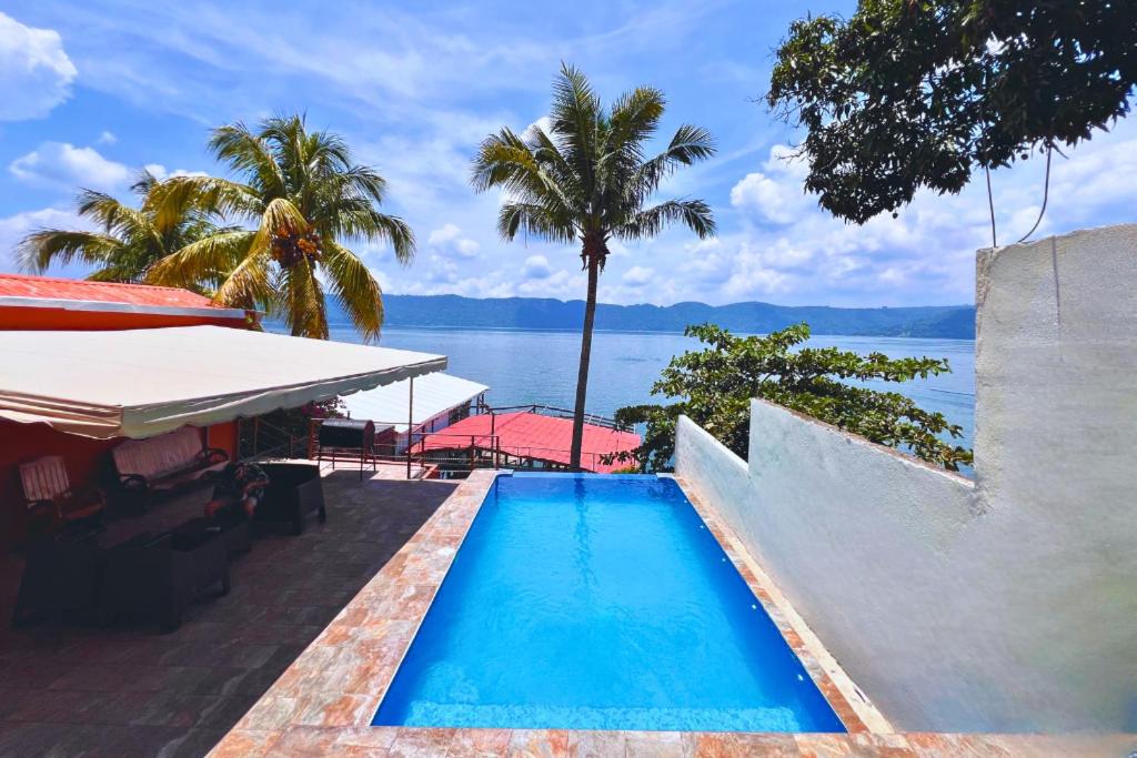 a swimming pool with a view of the water at Quinta Sunrise, Lago de Coatepeque in El Congo
