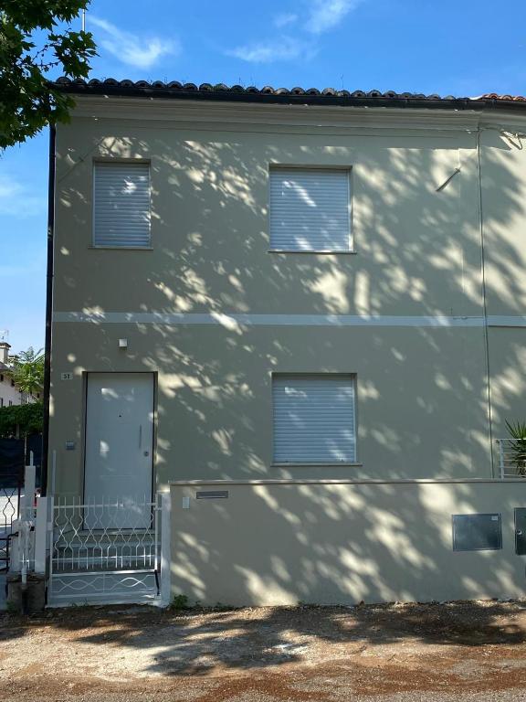 a building with three windows and a garage at La Magione in Fano