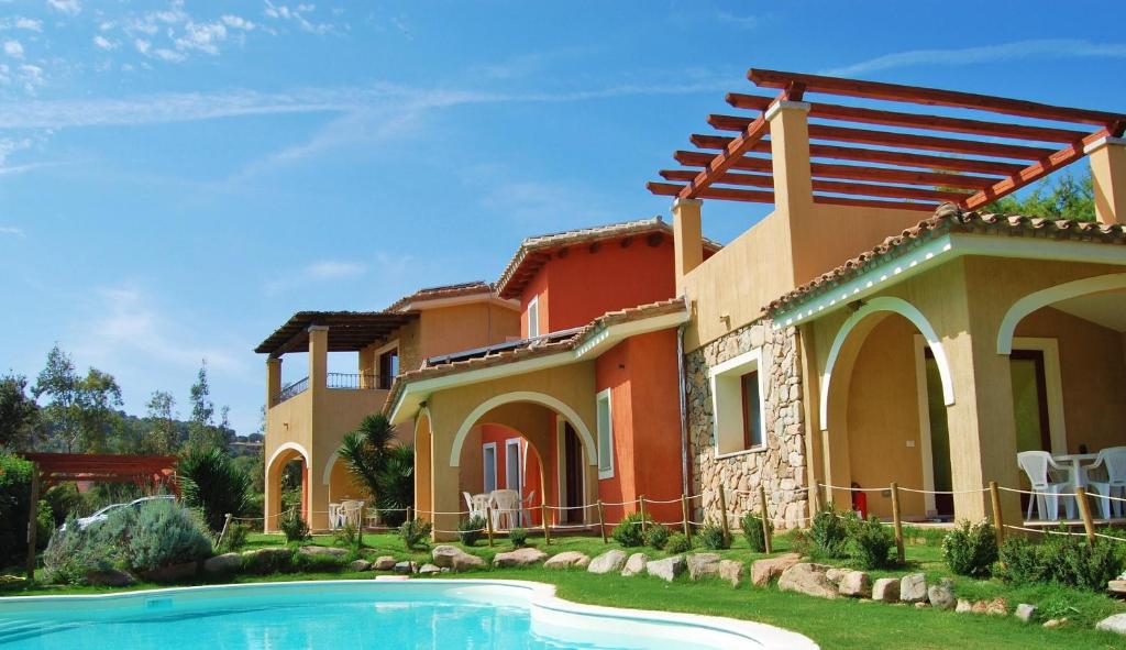 a house with a swimming pool in front of it at I Lentischi in Villasimius