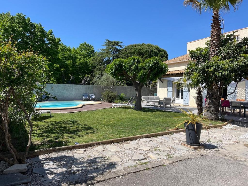 une cour arrière avec une piscine et une maison dans l'établissement Superbe Villa climatisée avec piscine, à Lavérune