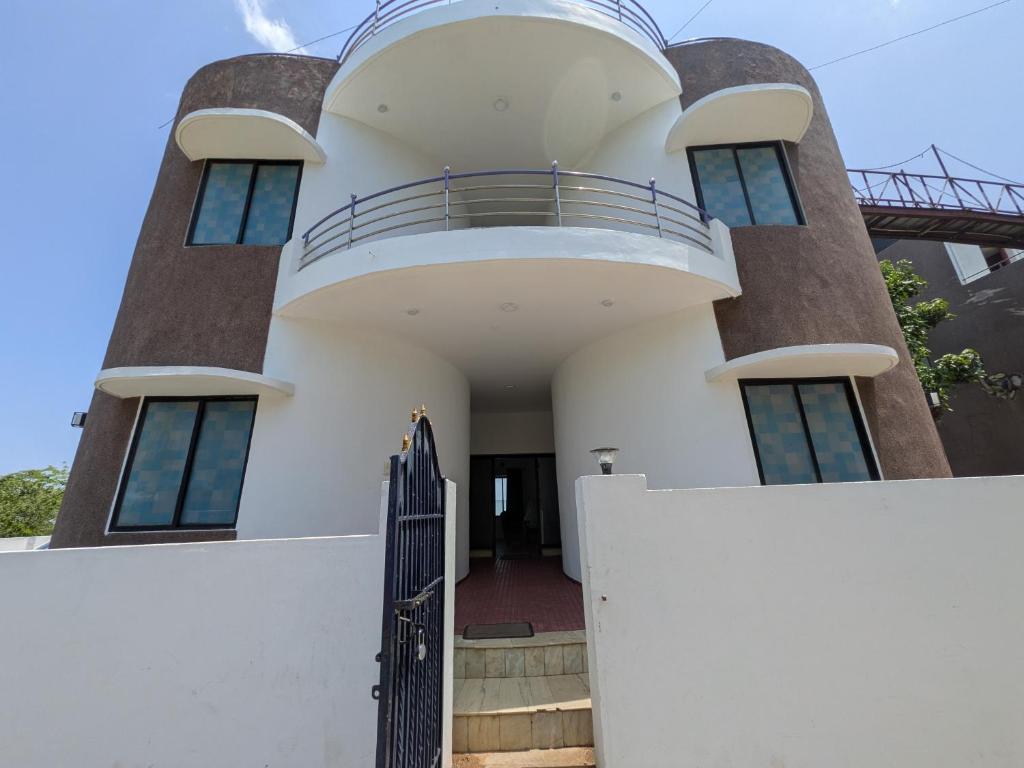 a white house with a gate and a fence at ANV Beach house in Kovakulam