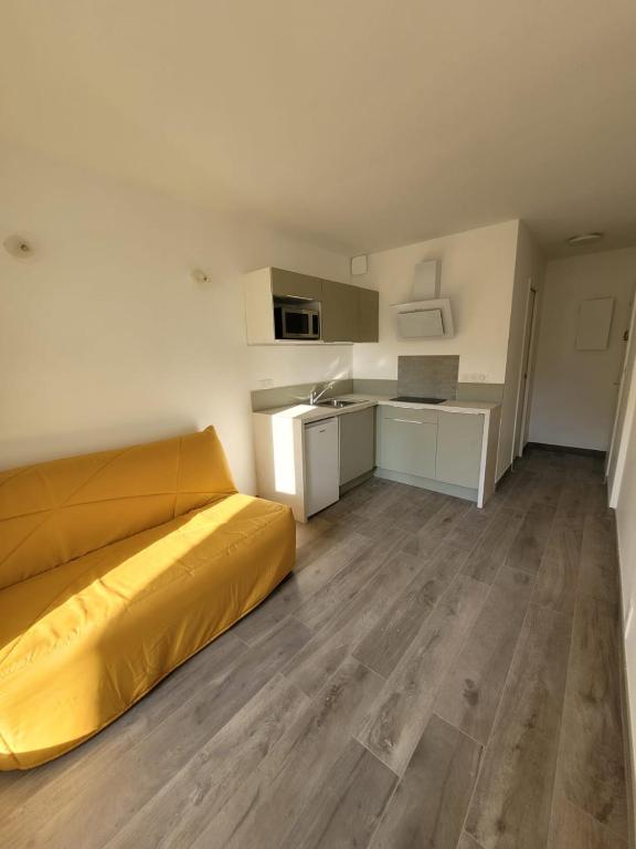 Cet appartement comprend une chambre avec un lit jaune et une cuisine. dans l'établissement Studio Saint Georges de Didonne, à Saint-Georges-de-Didonne