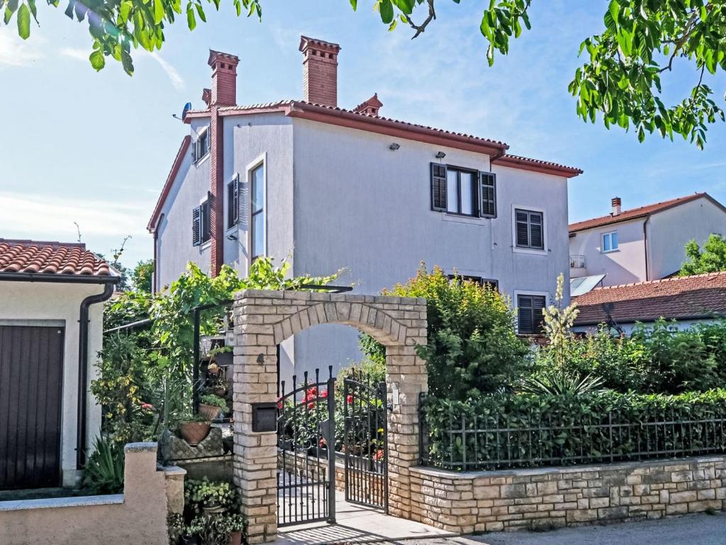 una casa bianca con un arco davanti a una recinzione di Apartment Dragica by Interhome a Pješčana Uvala