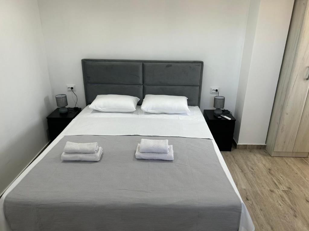 Un dormitorio con una cama grande con dos toallas encima. en Apartmani Filipovic, en Podgorica