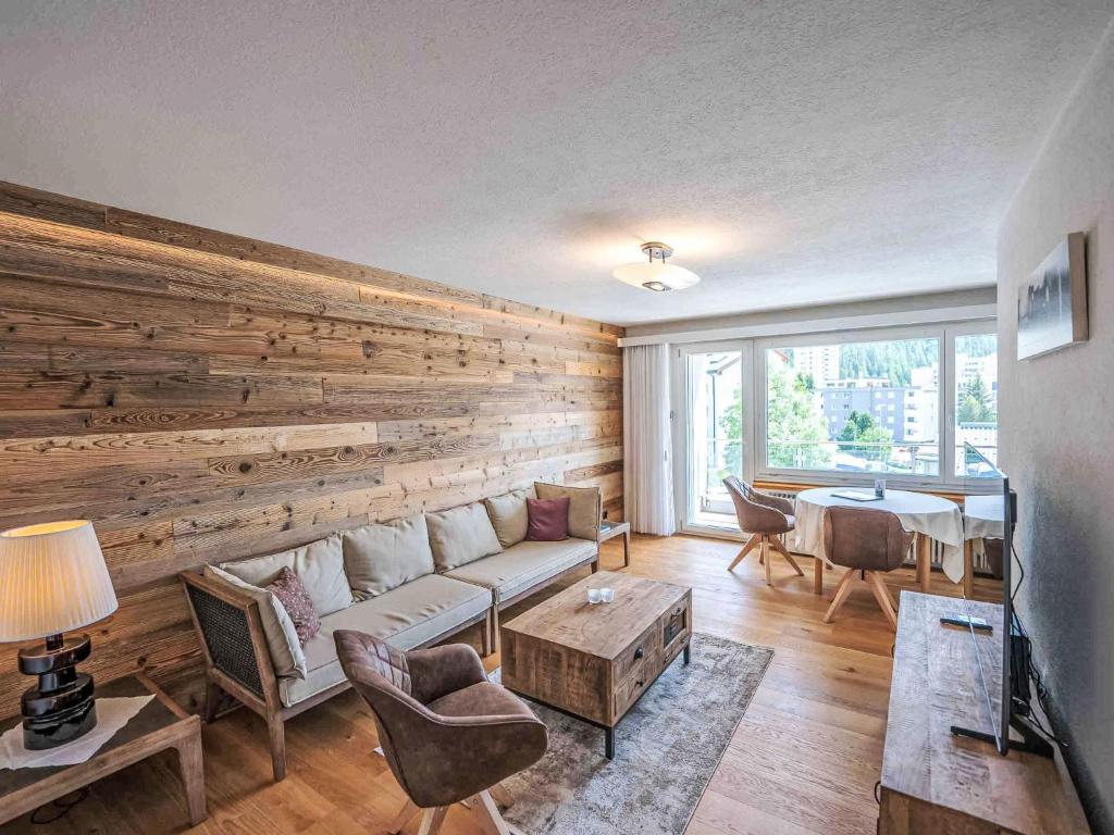 a living room with a couch and a wooden wall at Apartment Chesa Fleury by Interhome in St. Moritz