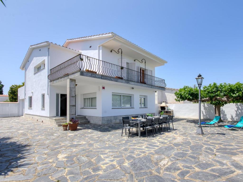 a house with a balcony and a table and chairs at Holiday Home Sant Mori by Interhome in Empuriabrava