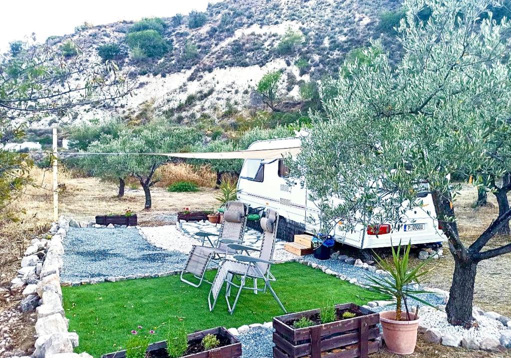 an rv parked in a yard with a table and chairs at Olive Grove Mountain Caravan in Limnatis