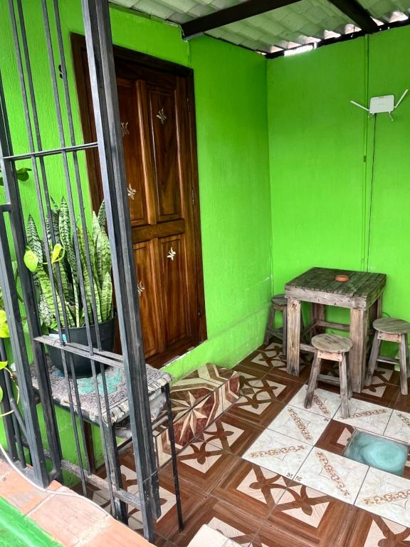 a room with green walls and a table and chairs at Jireh guesthouse in Antigua Guatemala