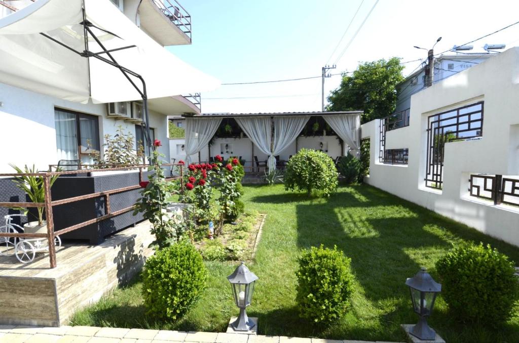 a backyard of a house with a lawn at Vila Bliss in Costinesti
