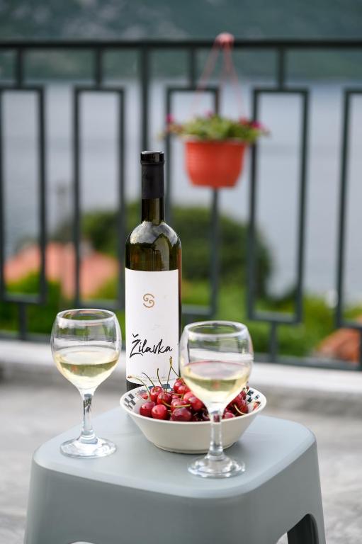 a bottle of wine and two glasses on a table at Palamida apartments in Banovina