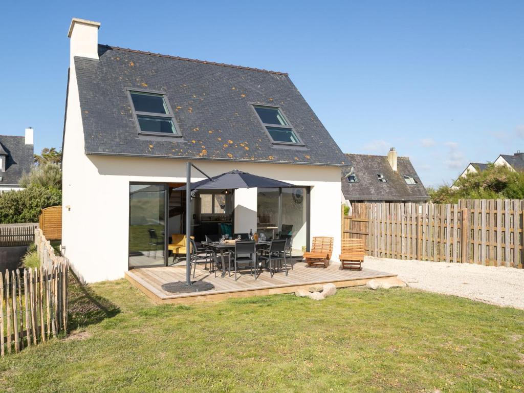 une maison avec une terrasse avec une table et des chaises dans l'établissement Holiday Home Les reflets bleus by Interhome, à Kerlouan
