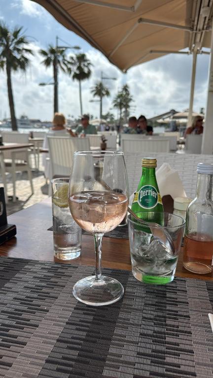 a glass of wine sitting on a table next to a bottle at Onero Residence Lovely Apartment in Paphos City