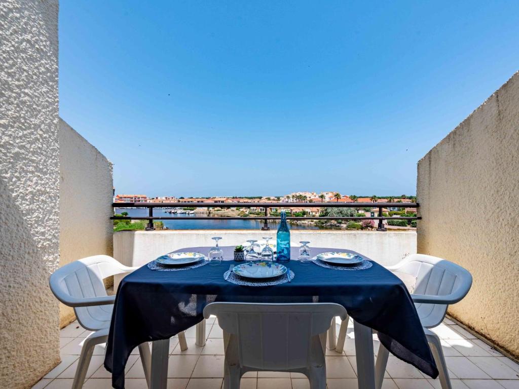 une table avec des chaises et un chiffon de table bleu sur un balcon dans l'établissement Apartment Coudalère - Jamaica-5 by Interhome, au Barcarès