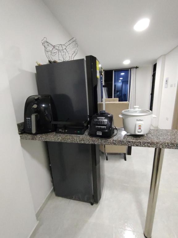 a kitchen counter with a microwave and a television on it at Confortable y Fresco Apartamento Girón in Girón