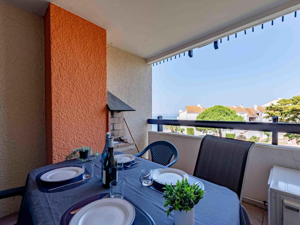 une table avec un chiffon bleu sur un balcon dans l'établissement Apartment Dominica-7 by Interhome, au Barcarès