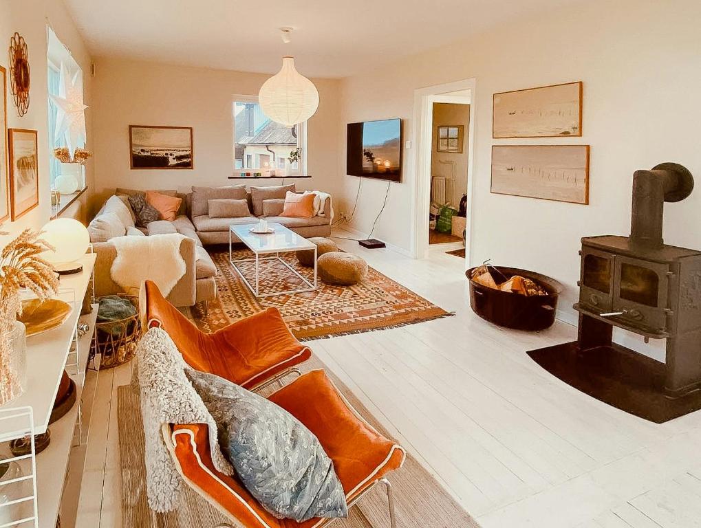 a living room with a couch and a wood stove at Bright House With Field View In Österlen in Borrby