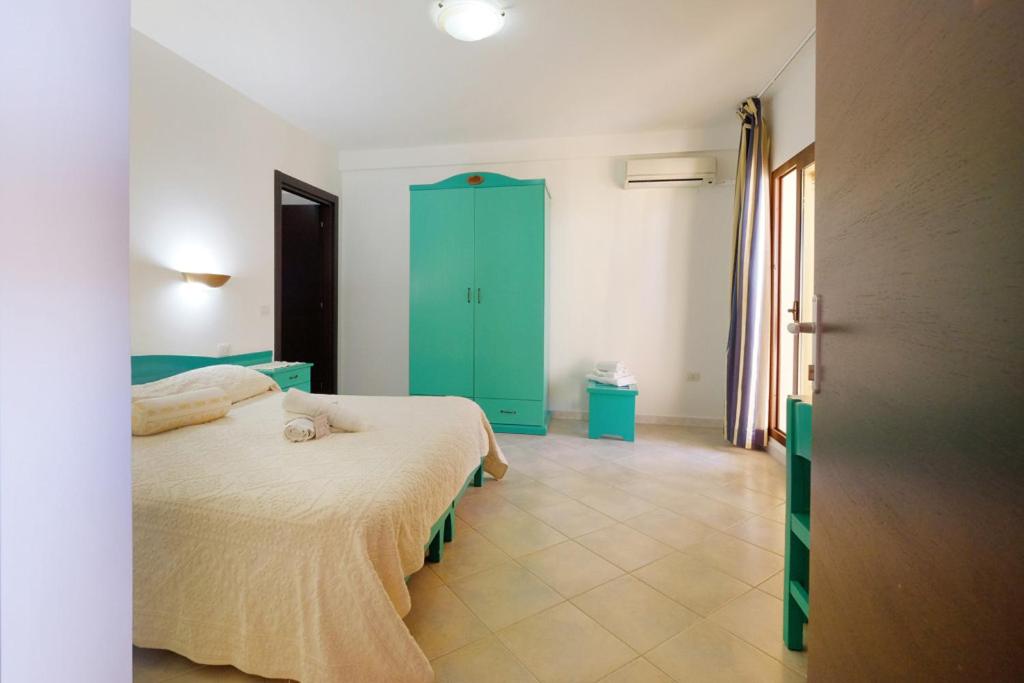 een slaapkamer met een bed en een groene kast bij Noa's in SantʼAnna Arresi