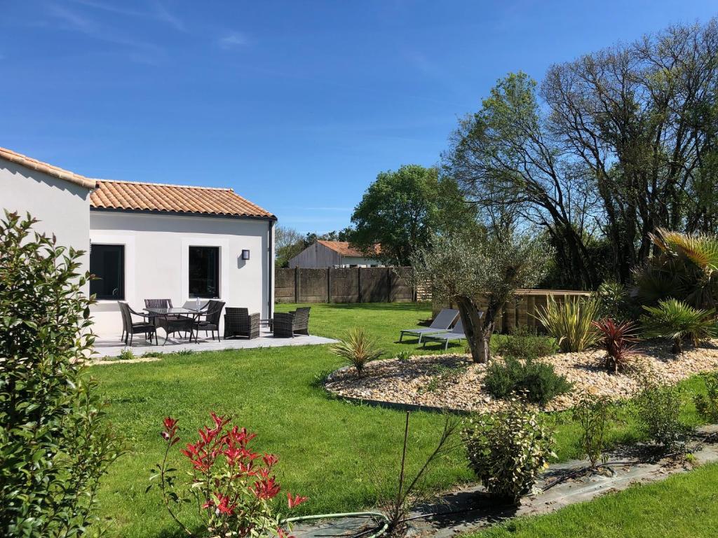 - un jardin avec une maison, une table et des chaises dans l'établissement Les rudali NewPort, à Chambon